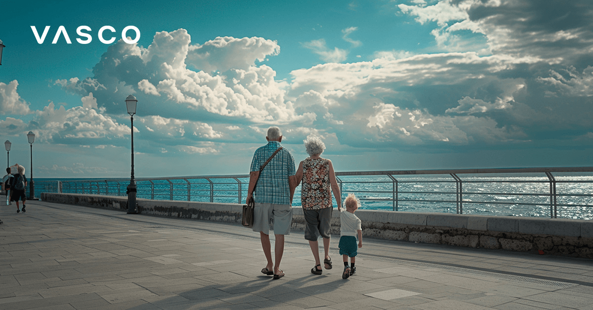 Starší pár s malým dítětem procházející promenádou podél pláže.