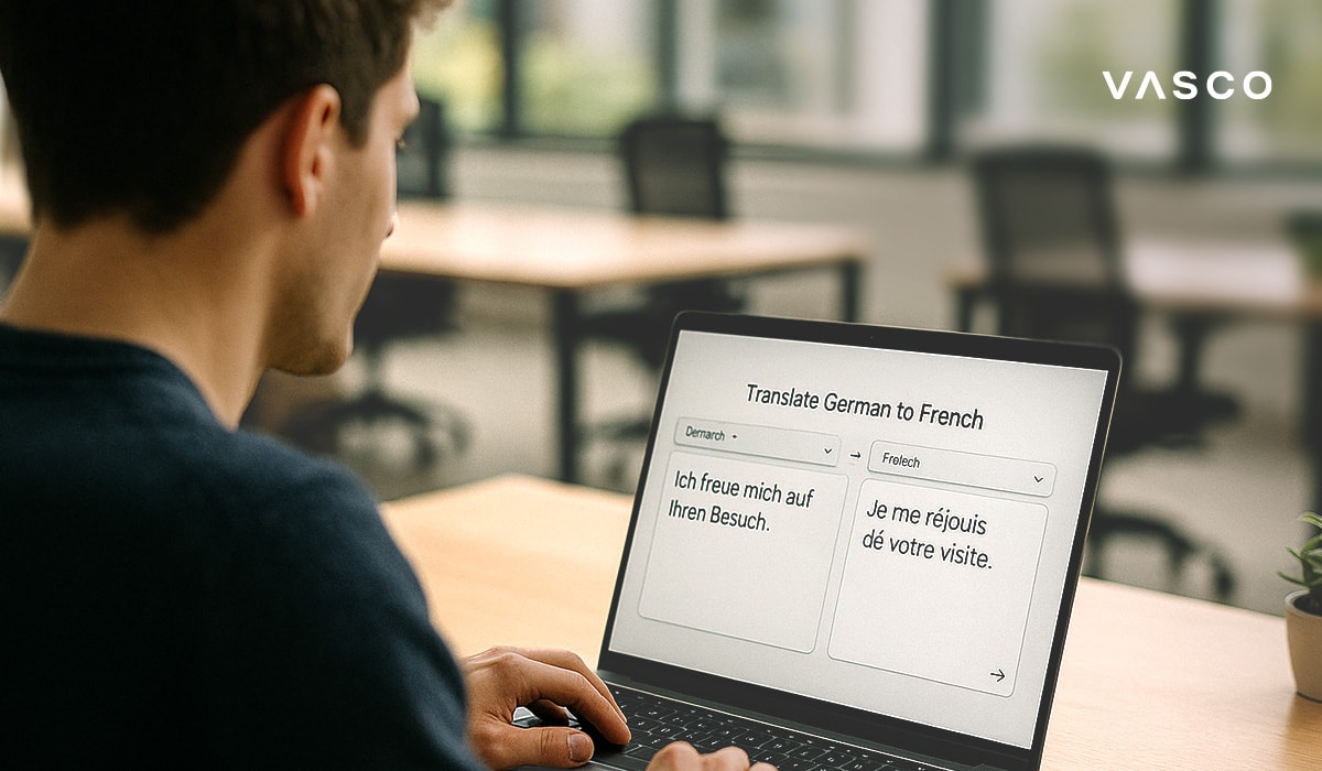 Muž používá notebook k překladu věty z němčiny do francouzštiny v moderním pracovním prostředí.