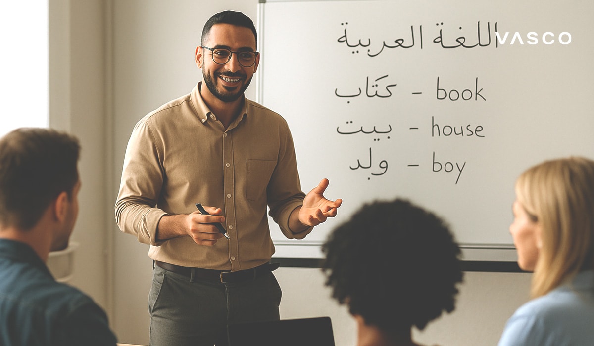 Usmívající se učitel během hodiny arabštiny s arabskými slovíčky a anglickými překlady na tabuli