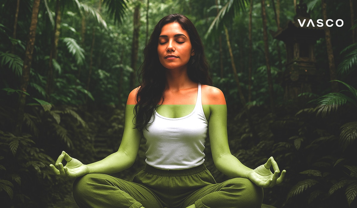Žena klidně meditující v lotosové pozici, obklopená bujnou zelení balijského lesa.