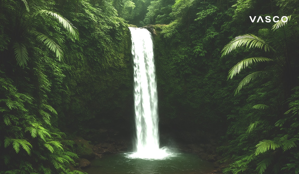 Majestátní vodopád řítící se do klidného jezírka uprostřed husté zelené tropické džungle.