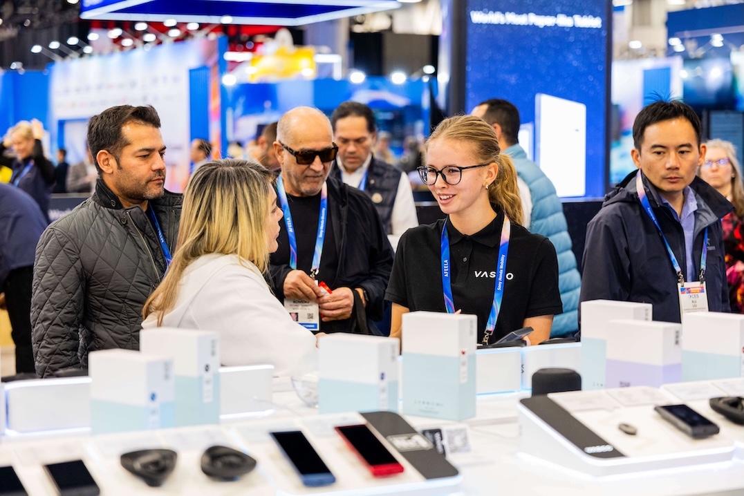 CES 2026 Skupina usmívajících se lidí diskutuje u stánku společnosti Vasco Electronics na veletrhu CES 2026.