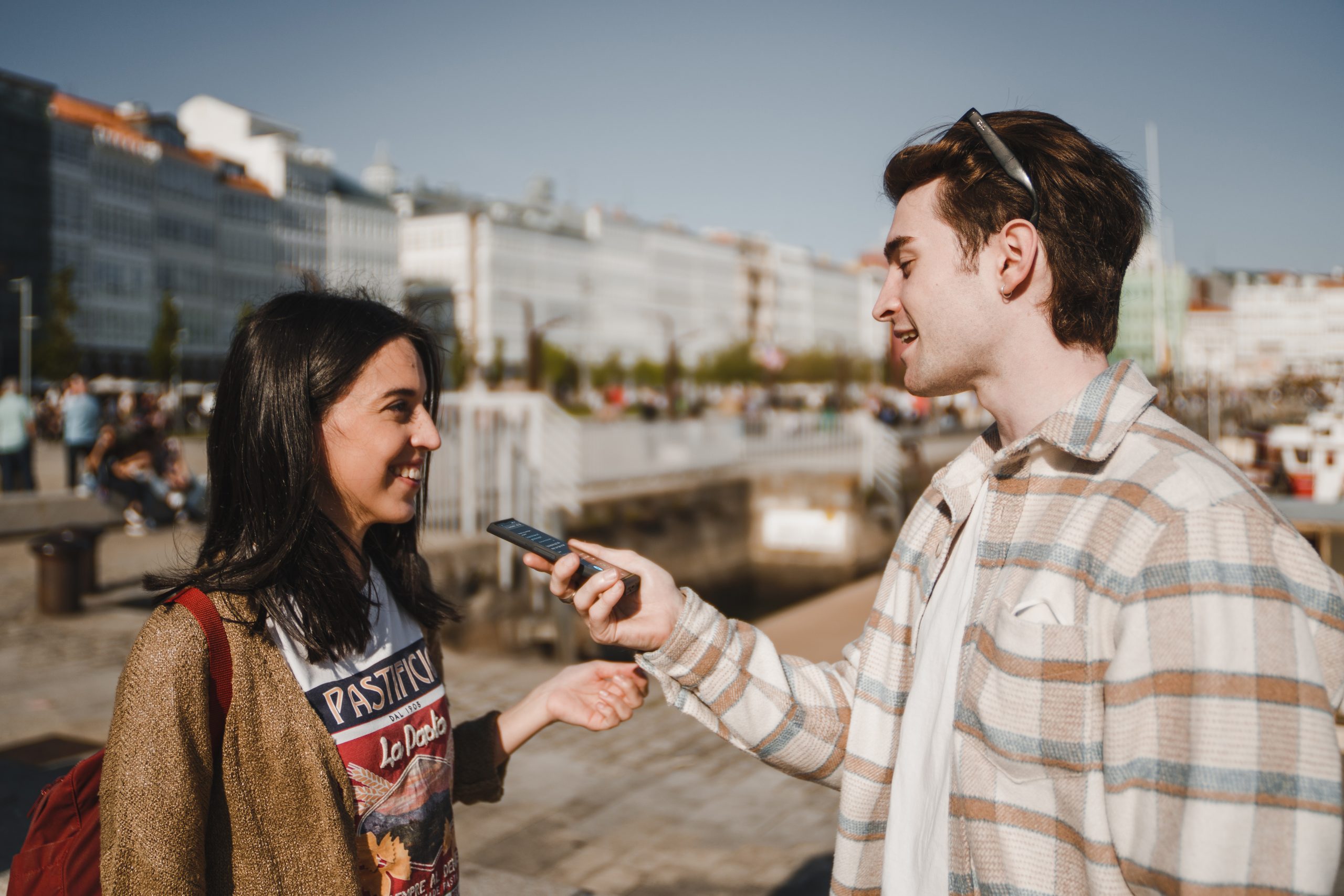 dva lidé se usmívají a baví se přes překladač
